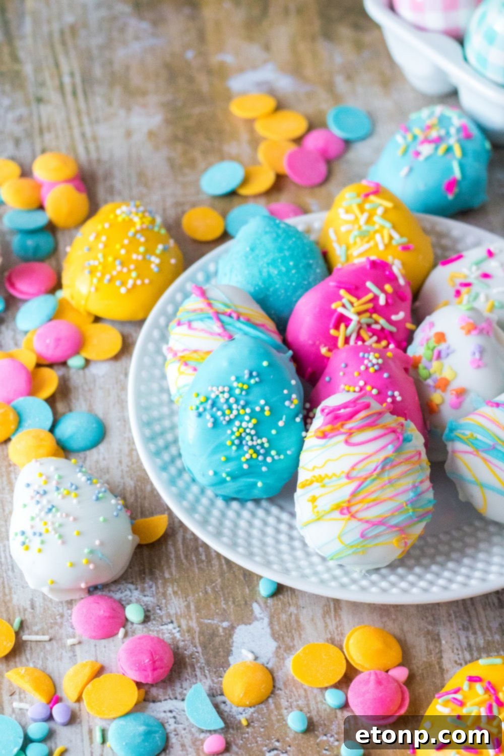 Easter Egg Oreo Truffles on tabl and on a white plate with candy melts and sprinkles decorated around it 