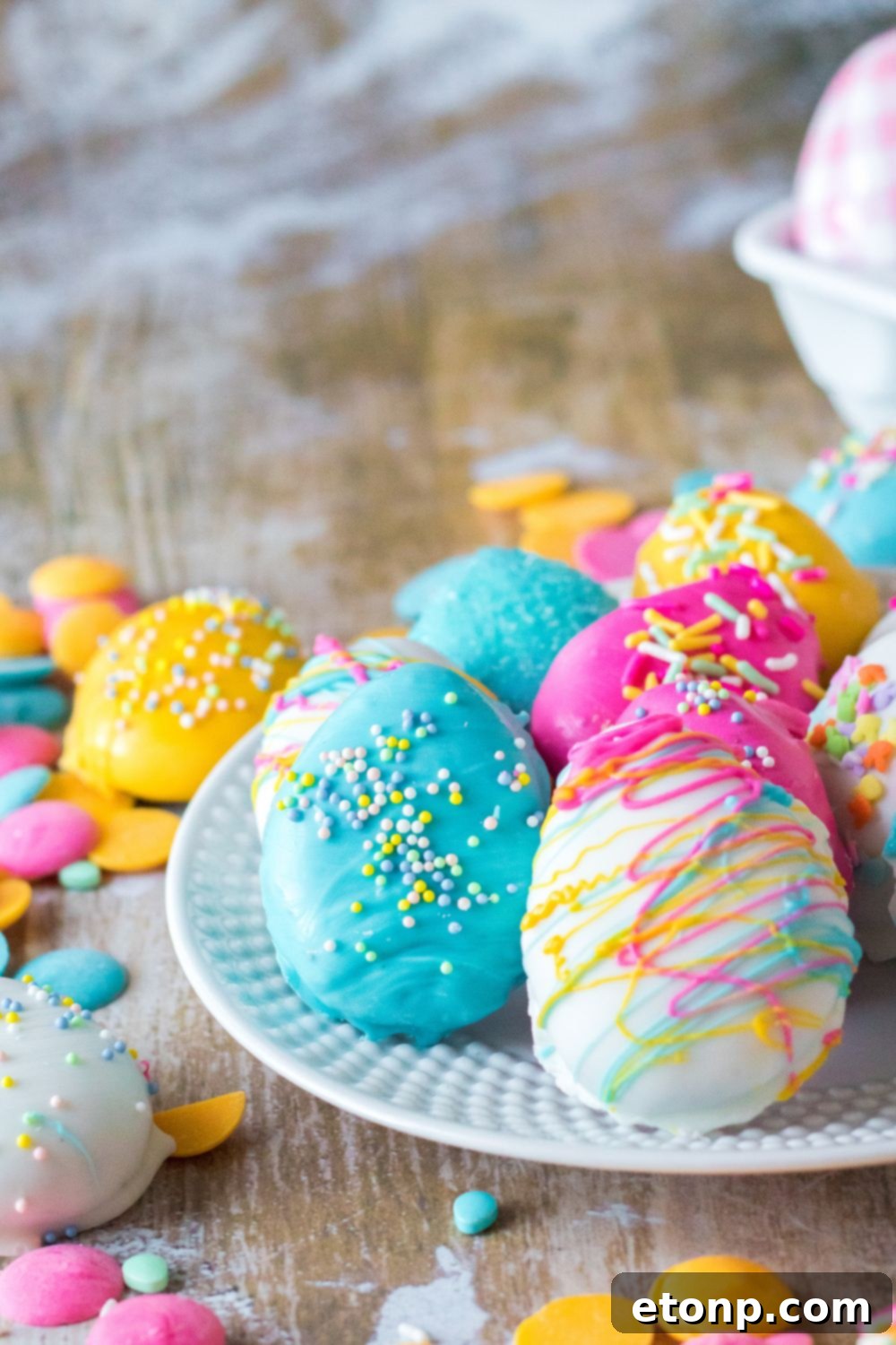 Easter Egg Oreo Truffles on table and on a white plate with sprinkles around it and Easter decor