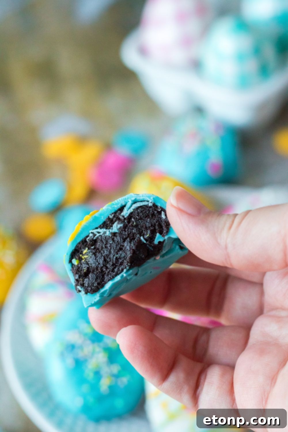 Easter Egg Oreo Truffle in hand bit in half to show the filling 