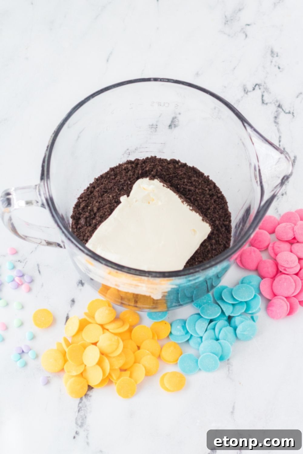 crushed oreos and a block of cream cheese in a measuring cup for the Easter Egg Oreo Truffles