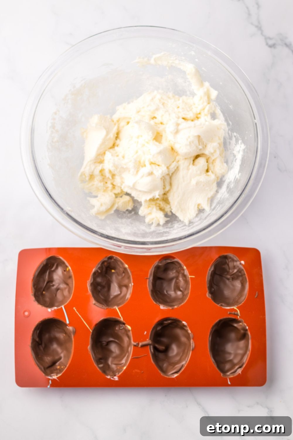 chocolate coating in a silicone mold ith marshmallow mixture in bowl by it for making a Easter Marshmallow Eggs