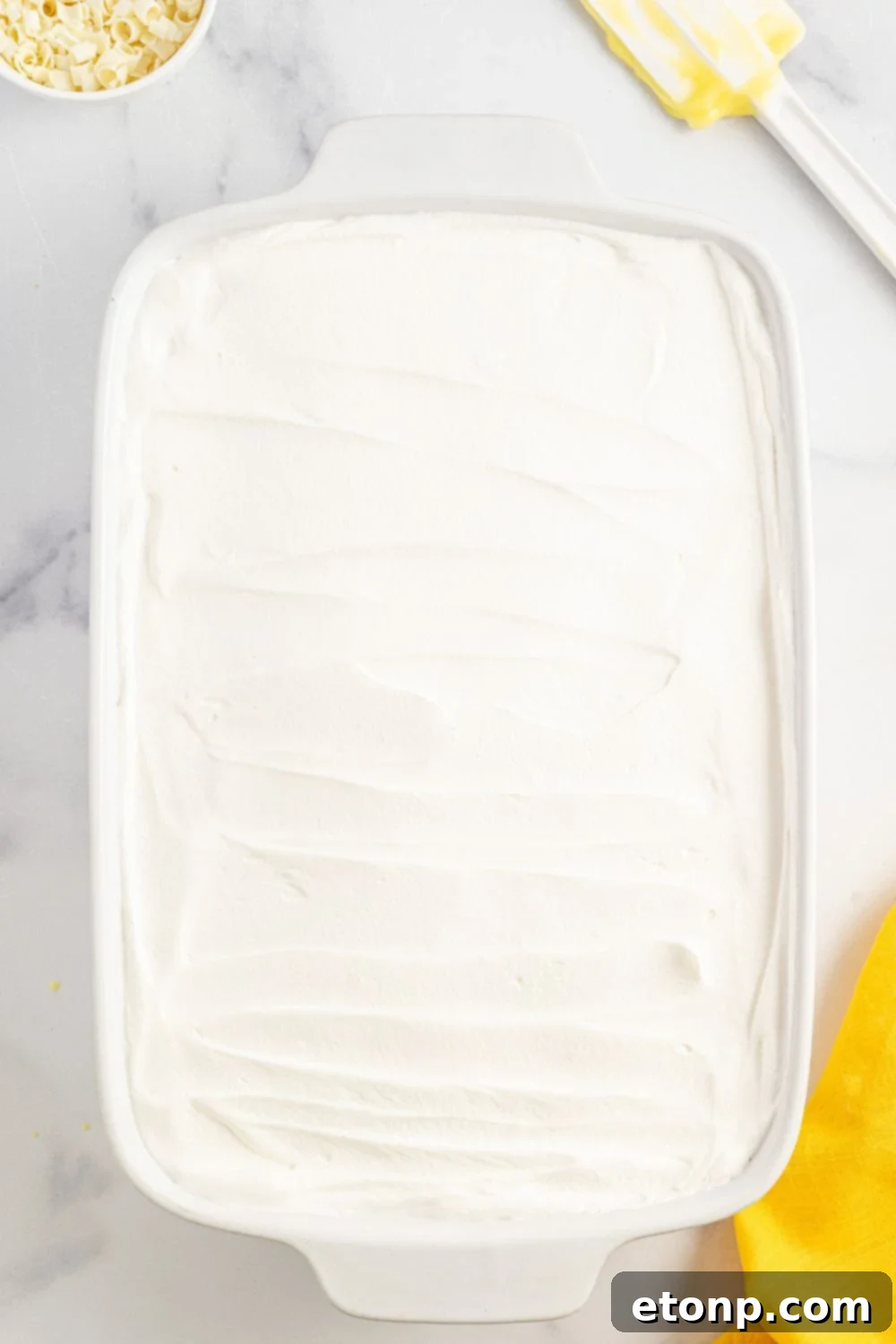 Lemon Blueberry Dream 12 whipped cream spread over the op of he Lemon Blueberry Lush dessert in pan