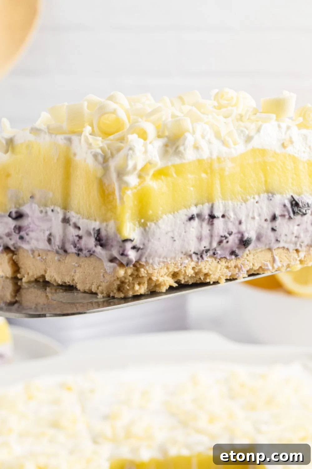 Lemon Blueberry Dream 15 Lemon Blueberry Lush dessert sliced and being lifted out of pan