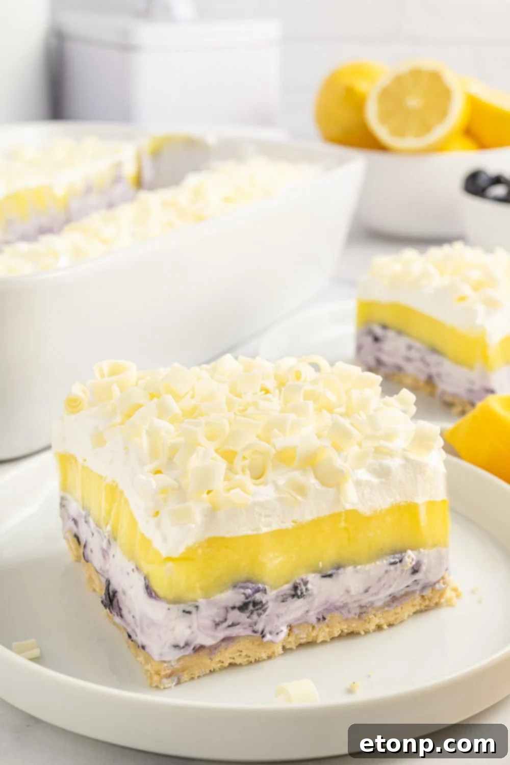 Lemon Blueberry Dream 17 slice of blueberry delight on plate wih more slices around it on table