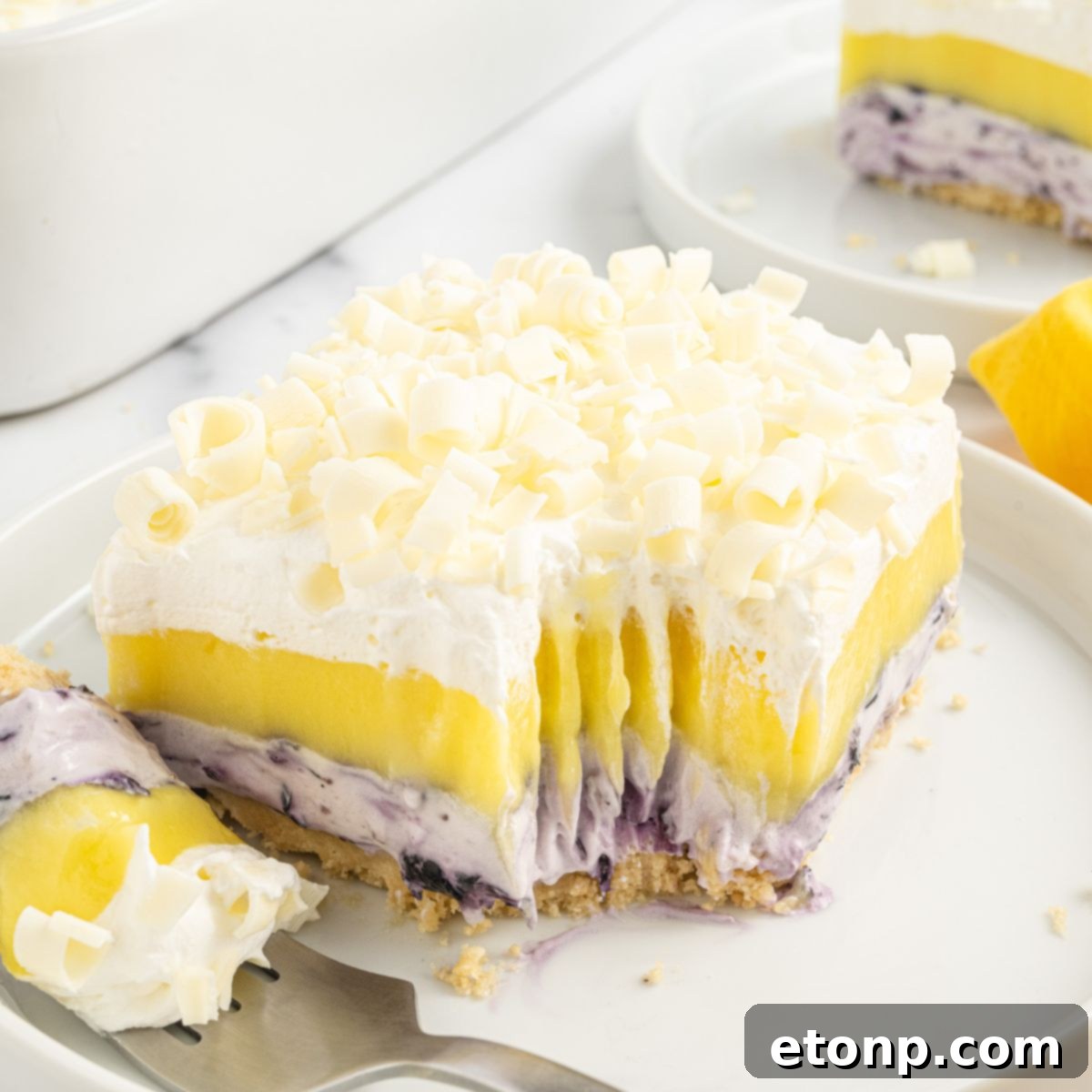 Lemon Blueberry Dream 3 Lemon Blueberry Lush sliced on plate with a fork with a bite on it