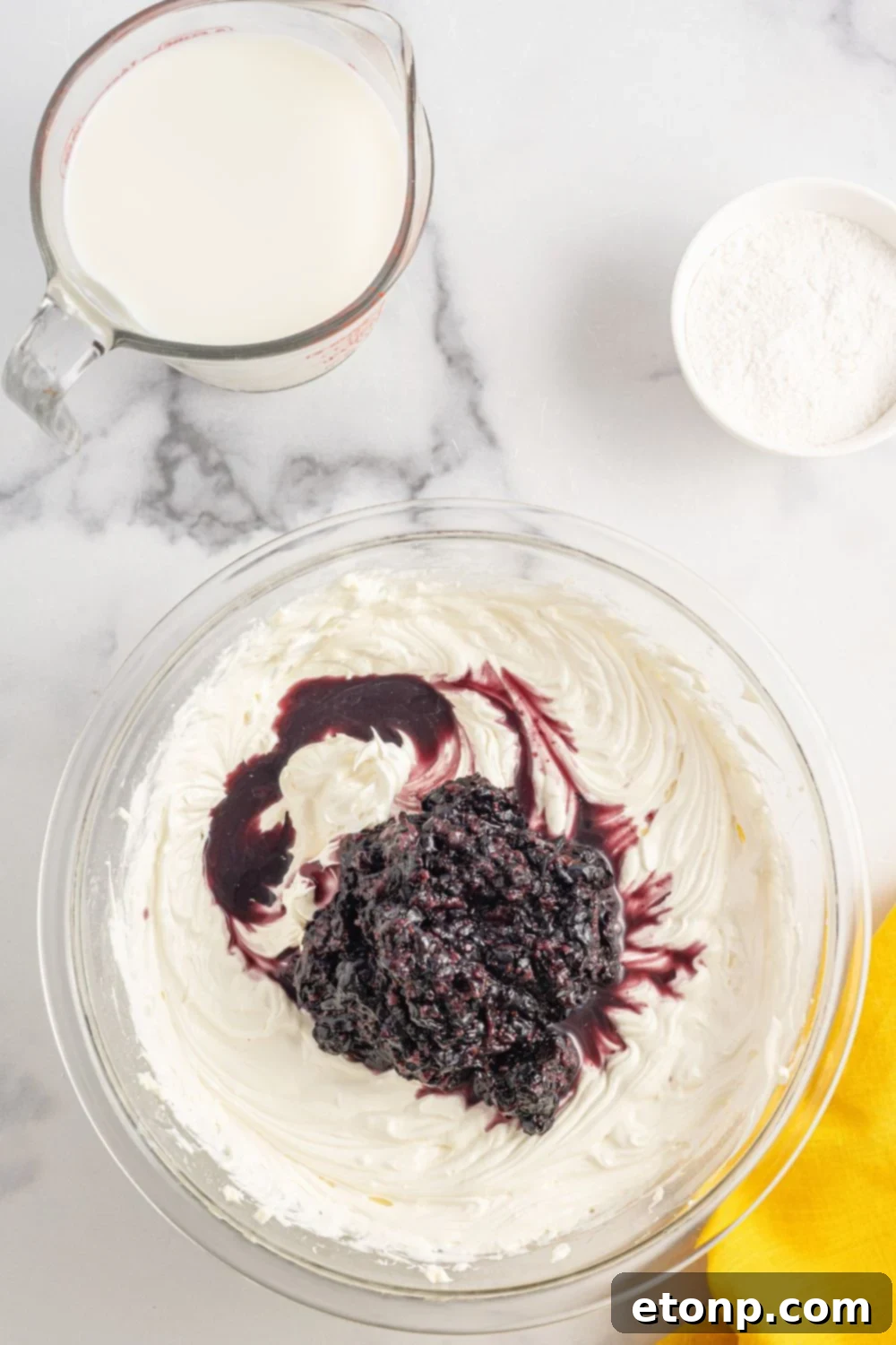 Lemon Blueberry Dream 9 Cream cheese and blueberry mixure in a bowl sitting on the table with other ingredients around it