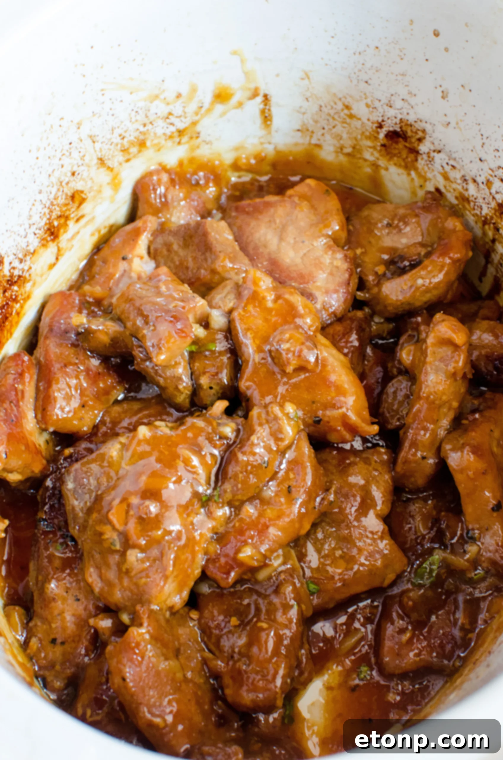 Another angle of the seared pork in the slow cooker, ready for sauce