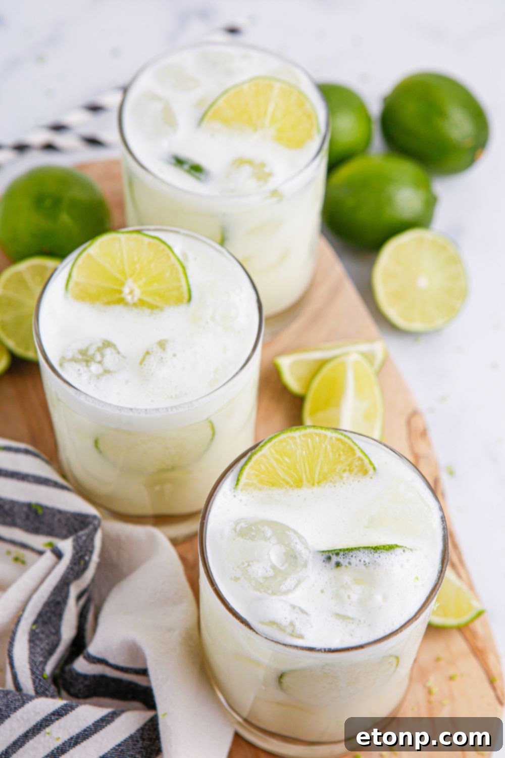 overhead look of brazilian lemonades in glasses with limes scattered on table