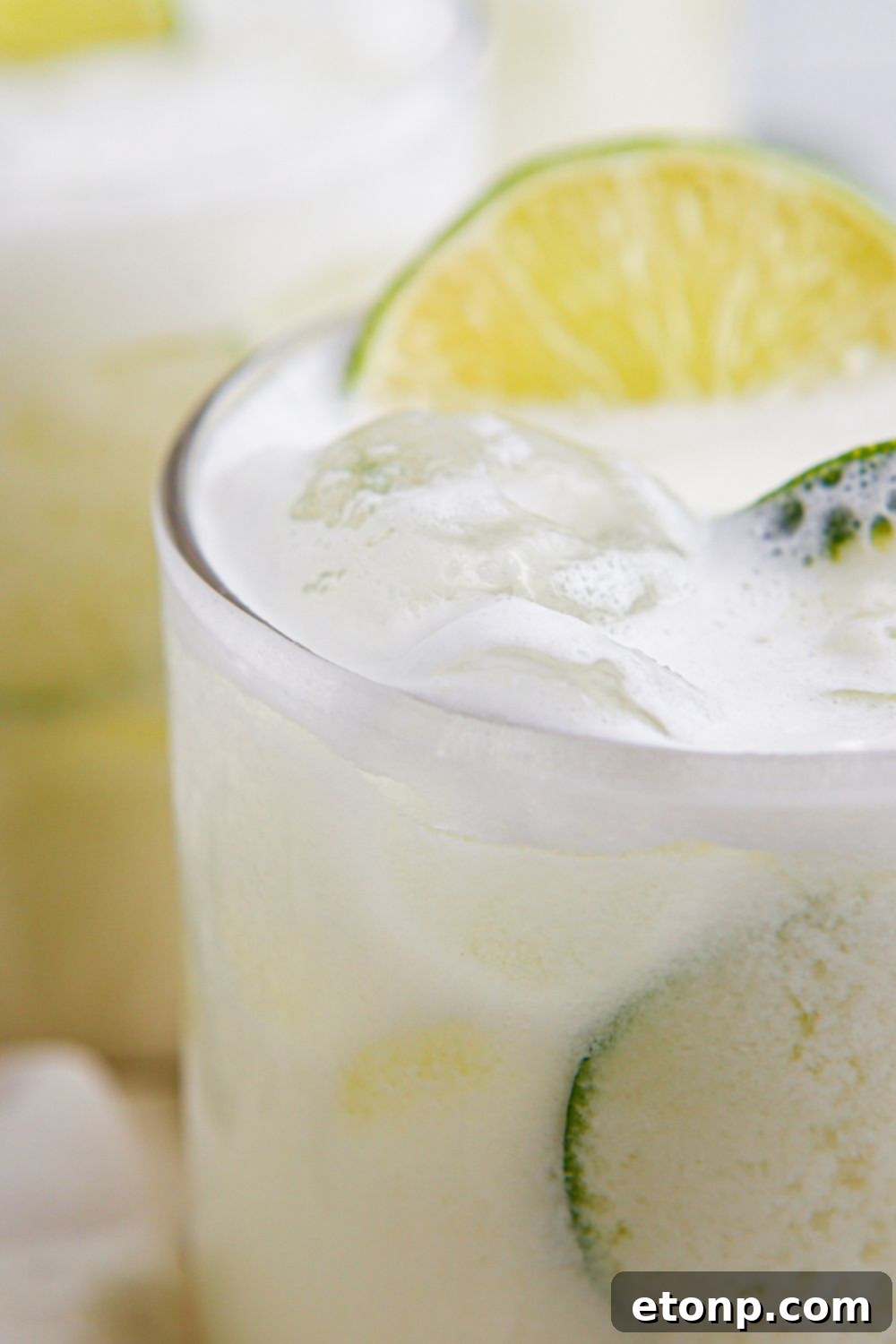 limade in glasses with a slice of lime in each glass