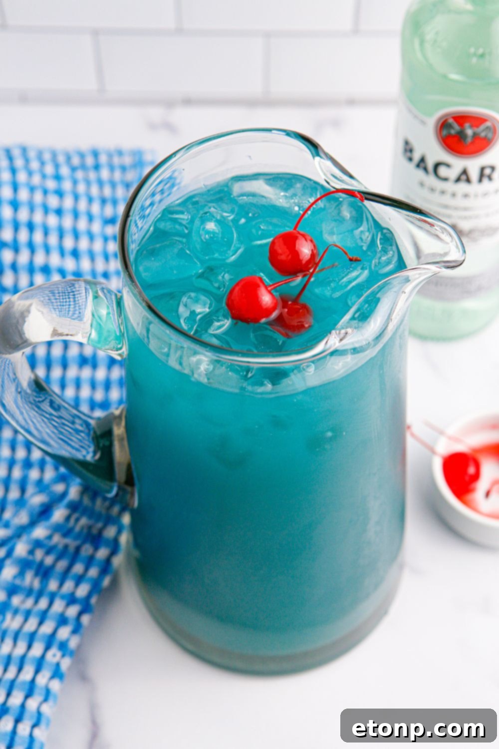 Blue Hawaiian Punch in a pitcher on table with a blue checkered towel around it