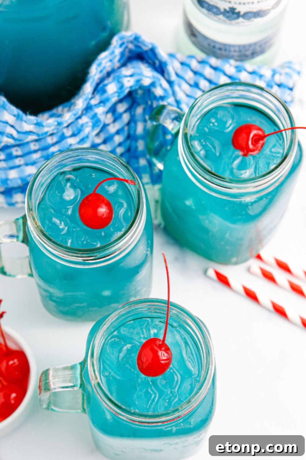 Blue Hawaiian Punch in a glass pitcher with fresh fruit garnish