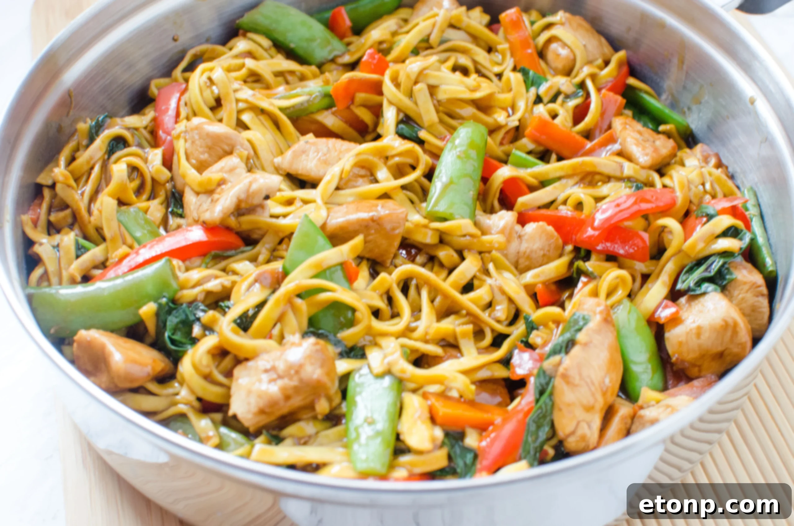 Full spread of chicken lo mein with garnishes