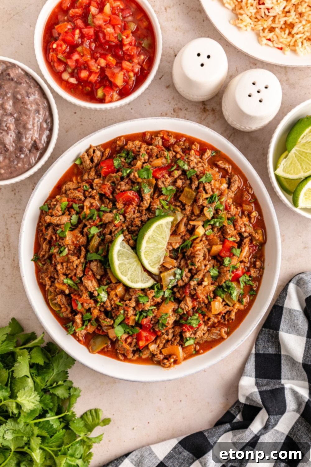 Ground Beef 15 overhead bowl of carne picada with lime wedges on top and ingredients around the bowl