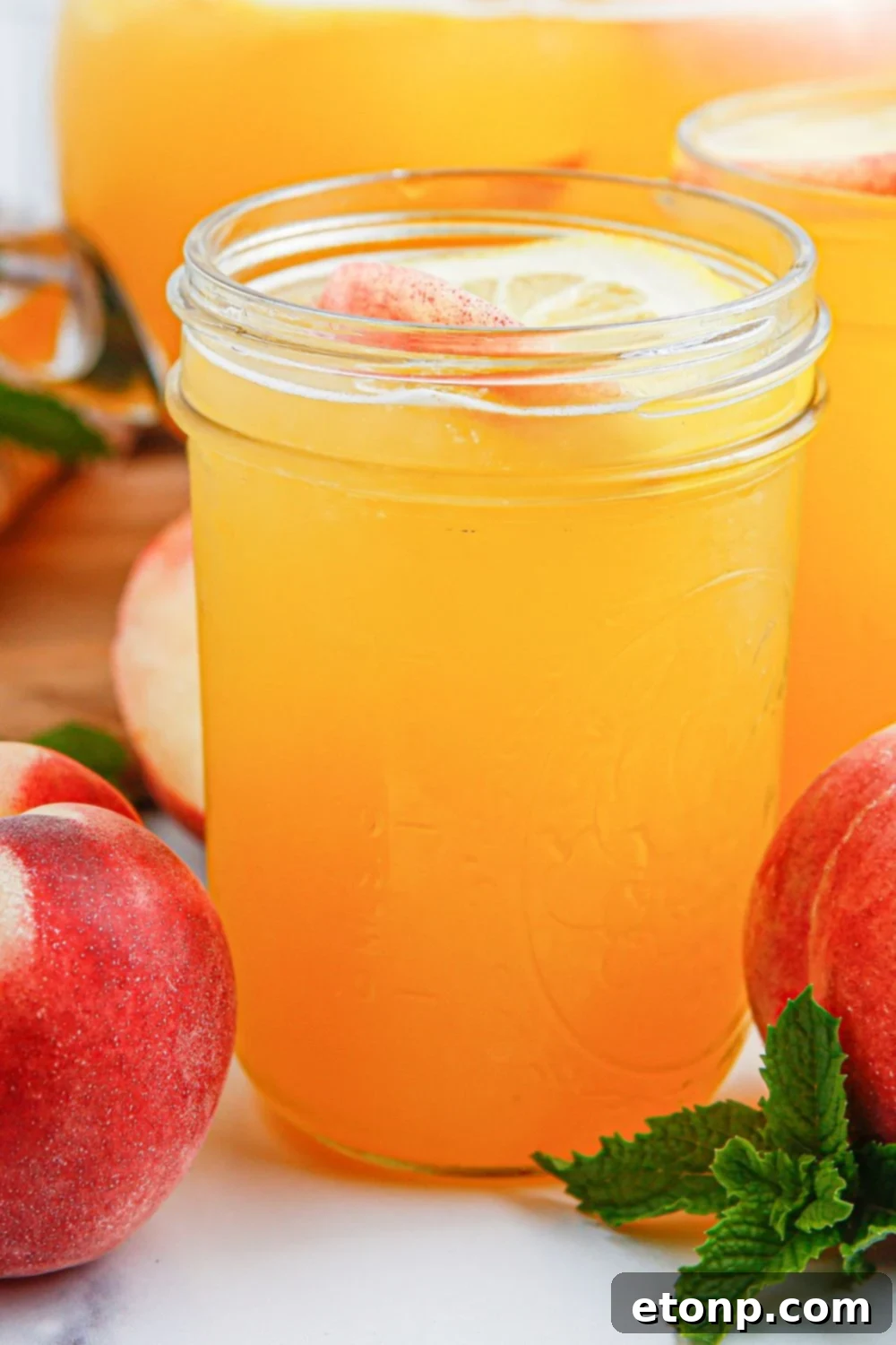 Glasses of fresh peach lemonade are presented on a wooden table, radiating a sense of cool refreshment, with their homemade charm evident in every detail and enticing for a taste.
