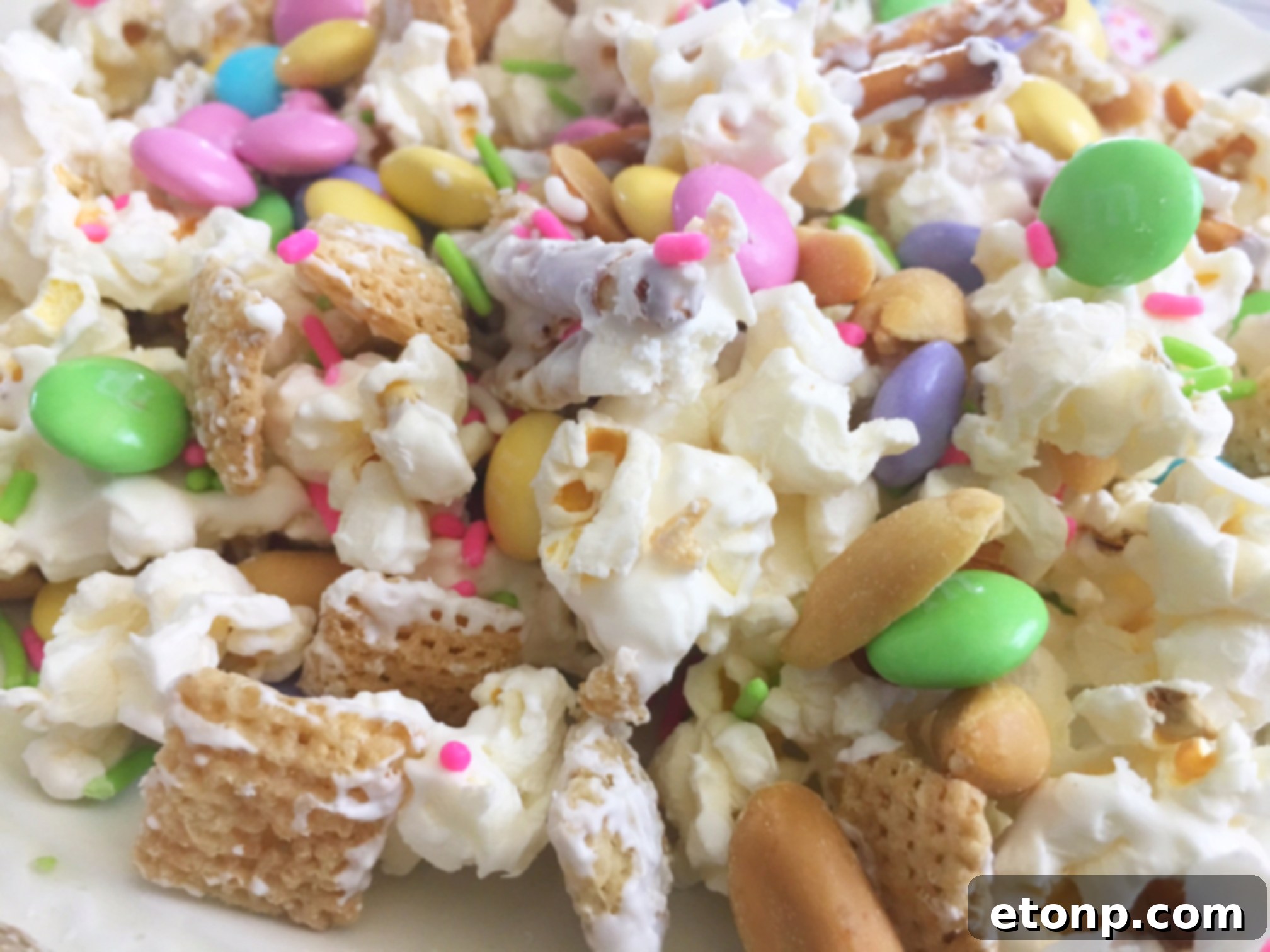 Bunny Bait snack mix spread out on parchment paper, showcasing the generous amount of M&Ms and sprinkles.