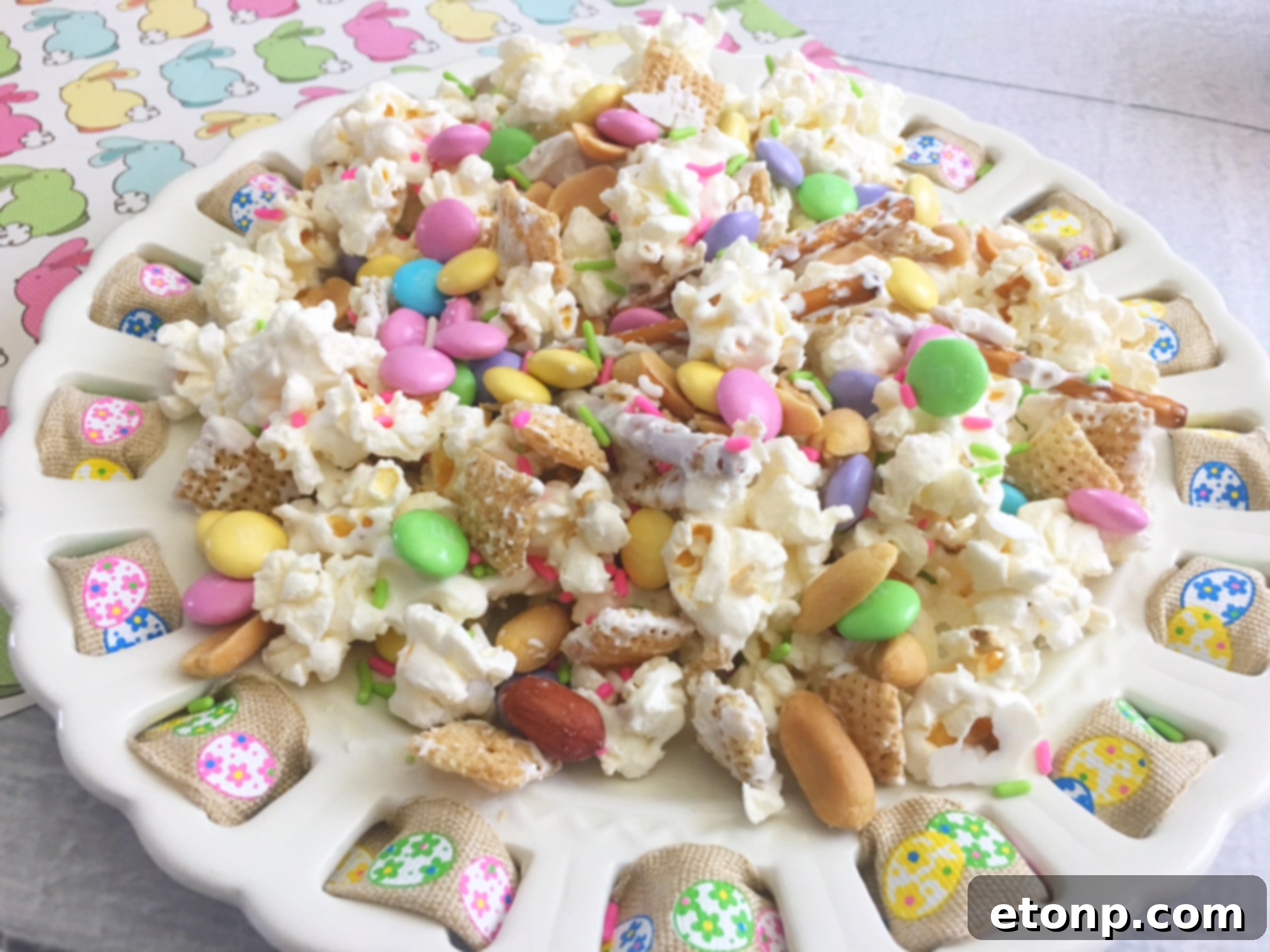 Close-up of the textured Bunny Bait snack mix with white chocolate, popcorn, and colorful Easter candies.