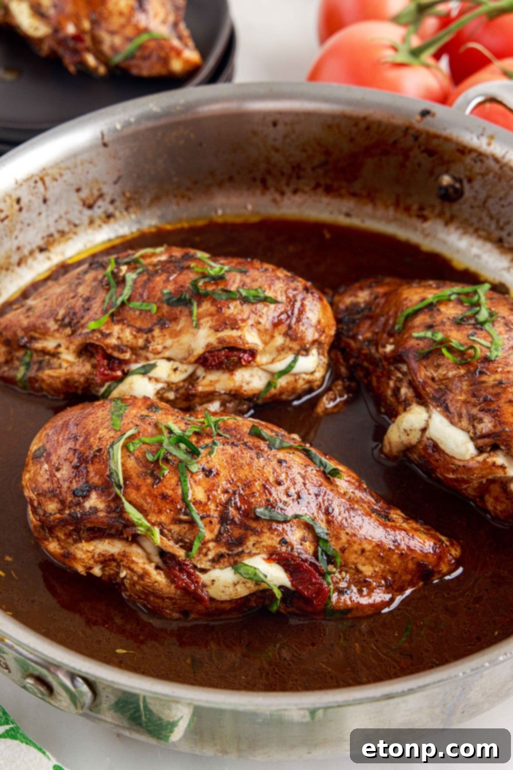 Caprese Stuffed Chicken in a skillet with sauce visible in the pan