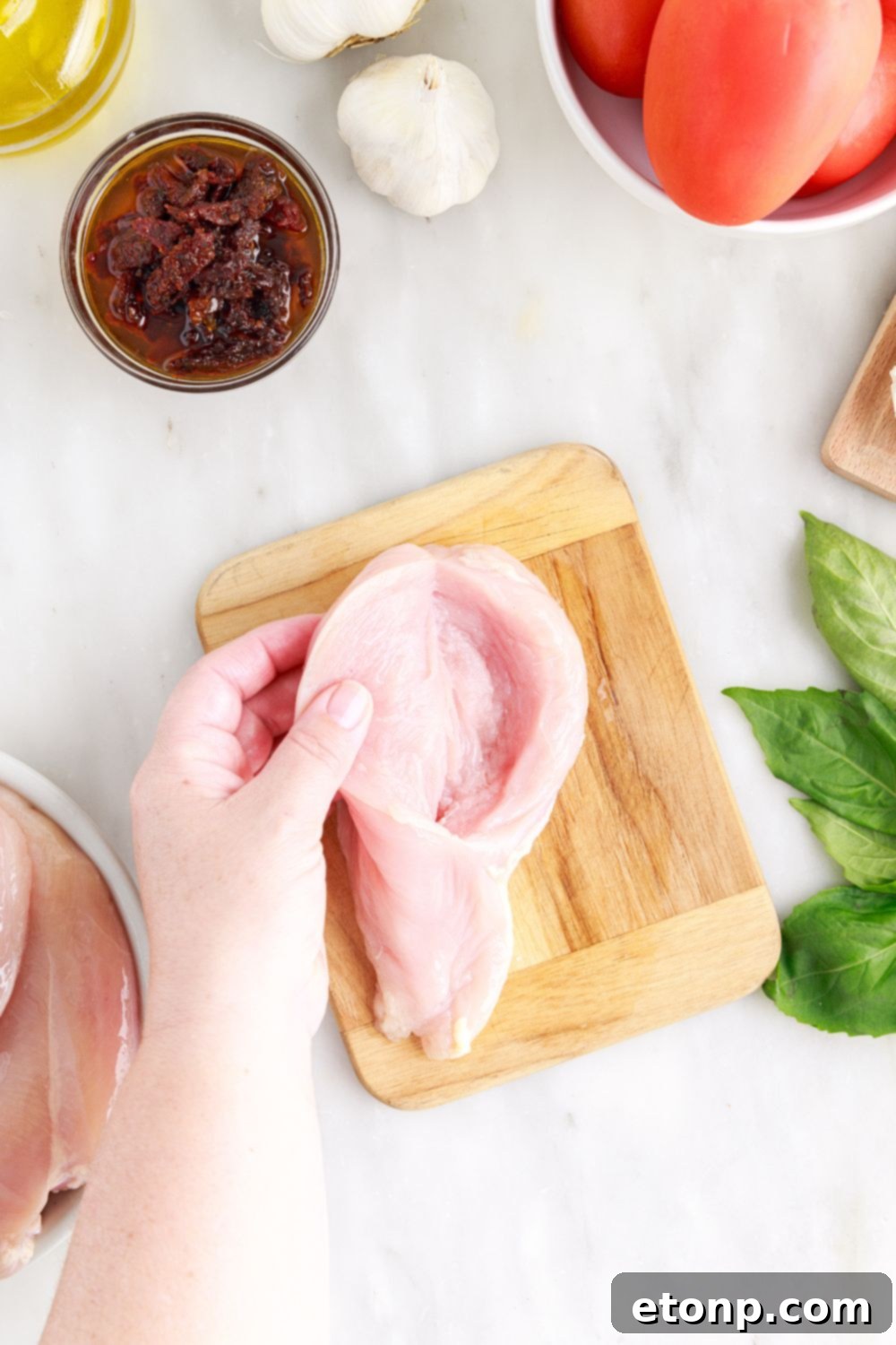 Butterfly cut raw chicken breast opened up to show the pocket for stuffing