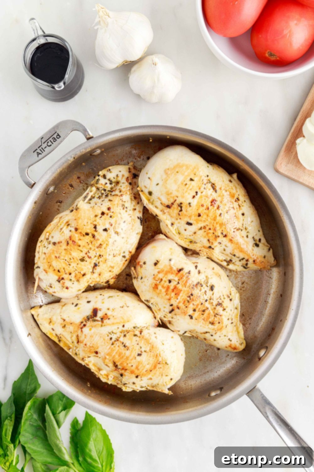 Partially cooked Caprese Stuffed Chicken searing in a skillet