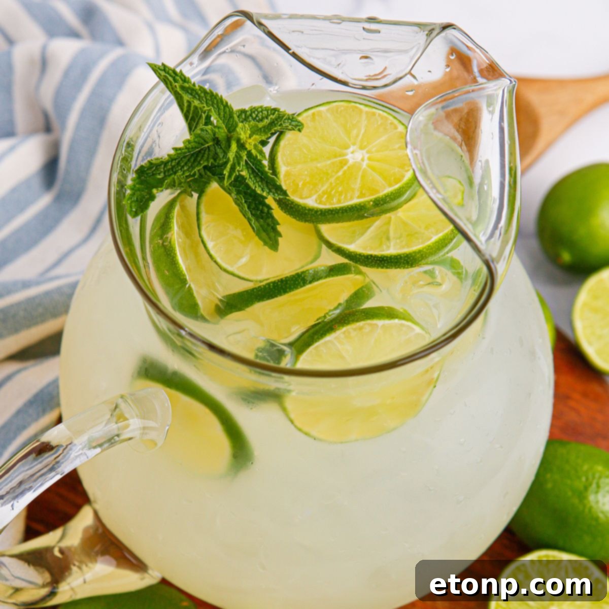 Limeade in a pitcher topped with sliced limes and mint leaves 