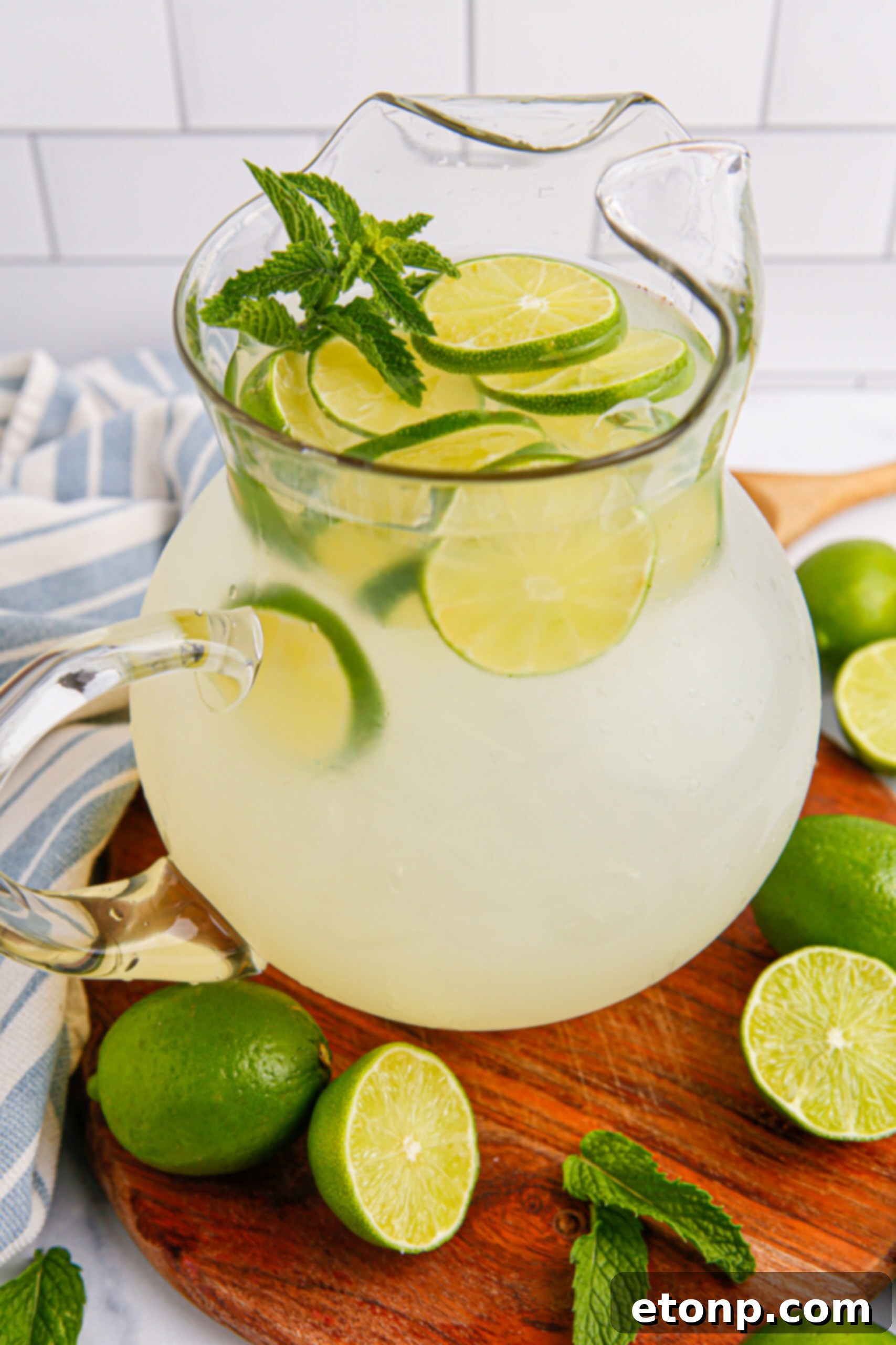 overhead look of pitcher with limeade in it, and scattered limes on table 