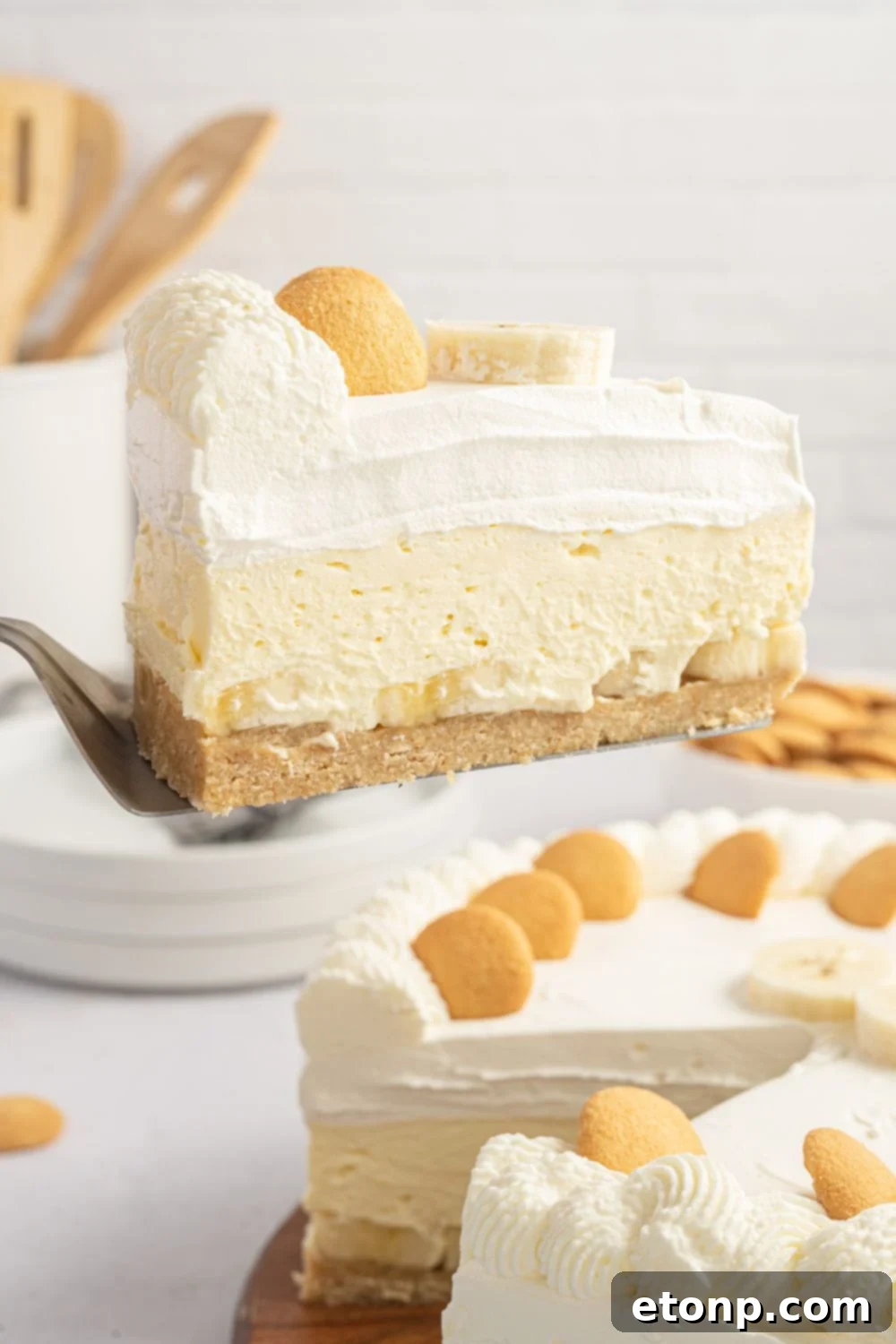 Dreamy No Bake Banana Pudding Cheesecake 13 A slice of banana pudding cheesecake being lifted out of the pan with a spatula, showing its perfect form.