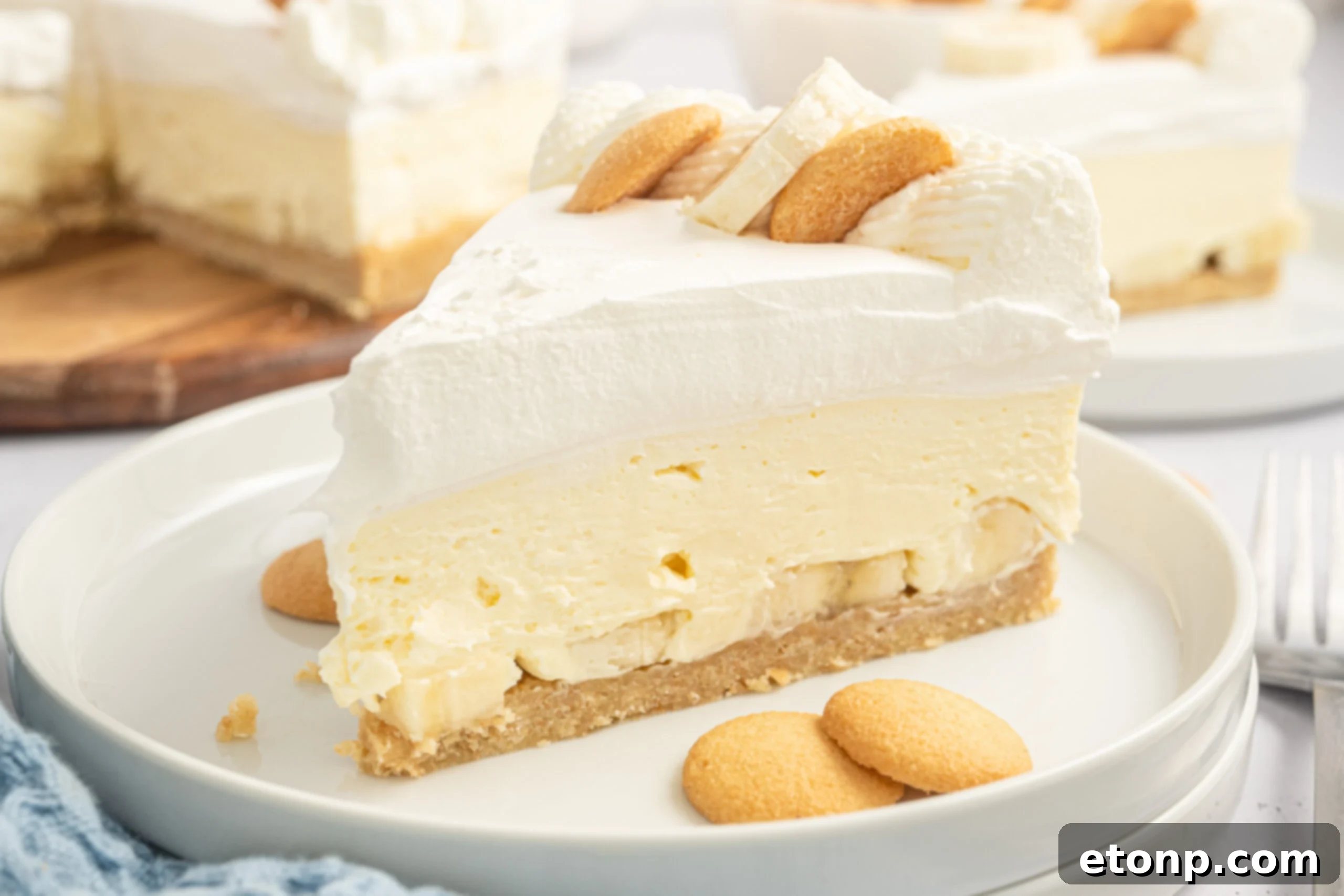 Dreamy No Bake Banana Pudding Cheesecake 21 Close-up view of several slices of banana pudding cheesecake on white plates.