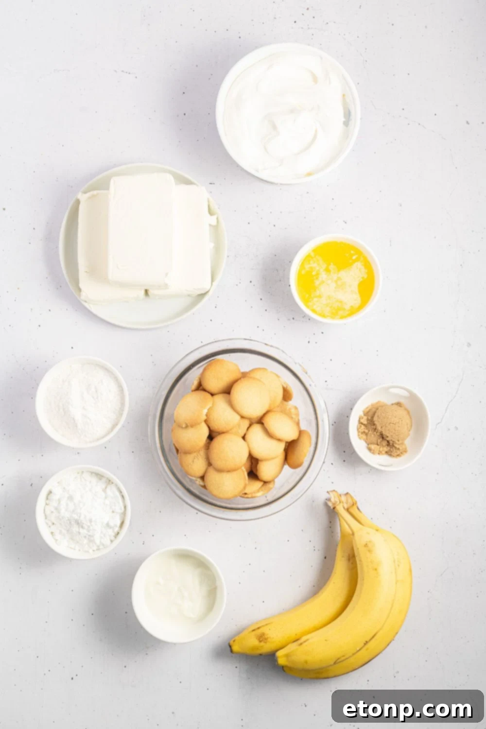 Dreamy No Bake Banana Pudding Cheesecake 6 All ingredients for No-Bake Banana Pudding Cheesecake laid out in individual bowls on a table.