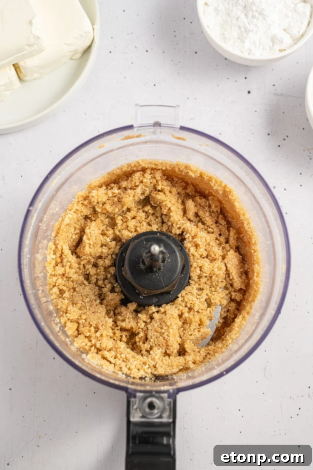 Dreamy No Bake Banana Pudding Cheesecake 7 Vanilla wafers being crushed in a food processor, ready for the crust.