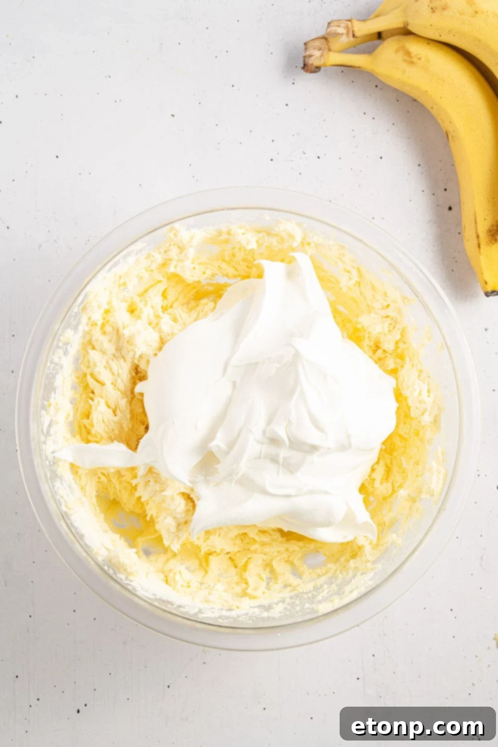 Dreamy No Bake Banana Pudding Cheesecake 10 Banana pudding filling mixed with whipped cream, creating a light and airy texture.