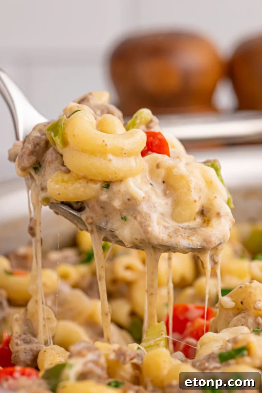 spoon above pan full of Philly Cheesesteak Pasta