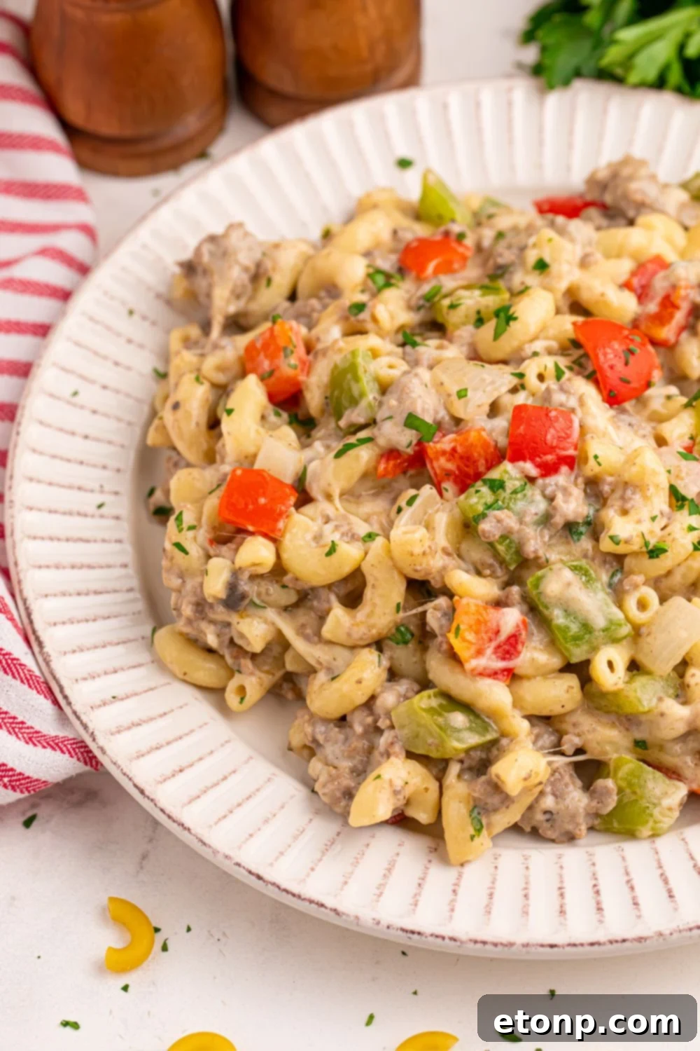 side view of plate on table with philly cheesesteak pasta on the plate
