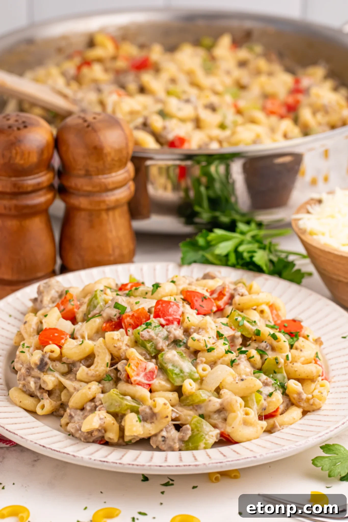 Philly Cheesesteak Pasta in a skillet in the background with a plate full in front 