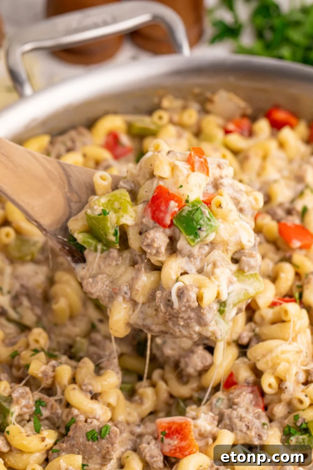 Philly Cheesesteak Pasta in skillet with a spatula scooping some pasta up 