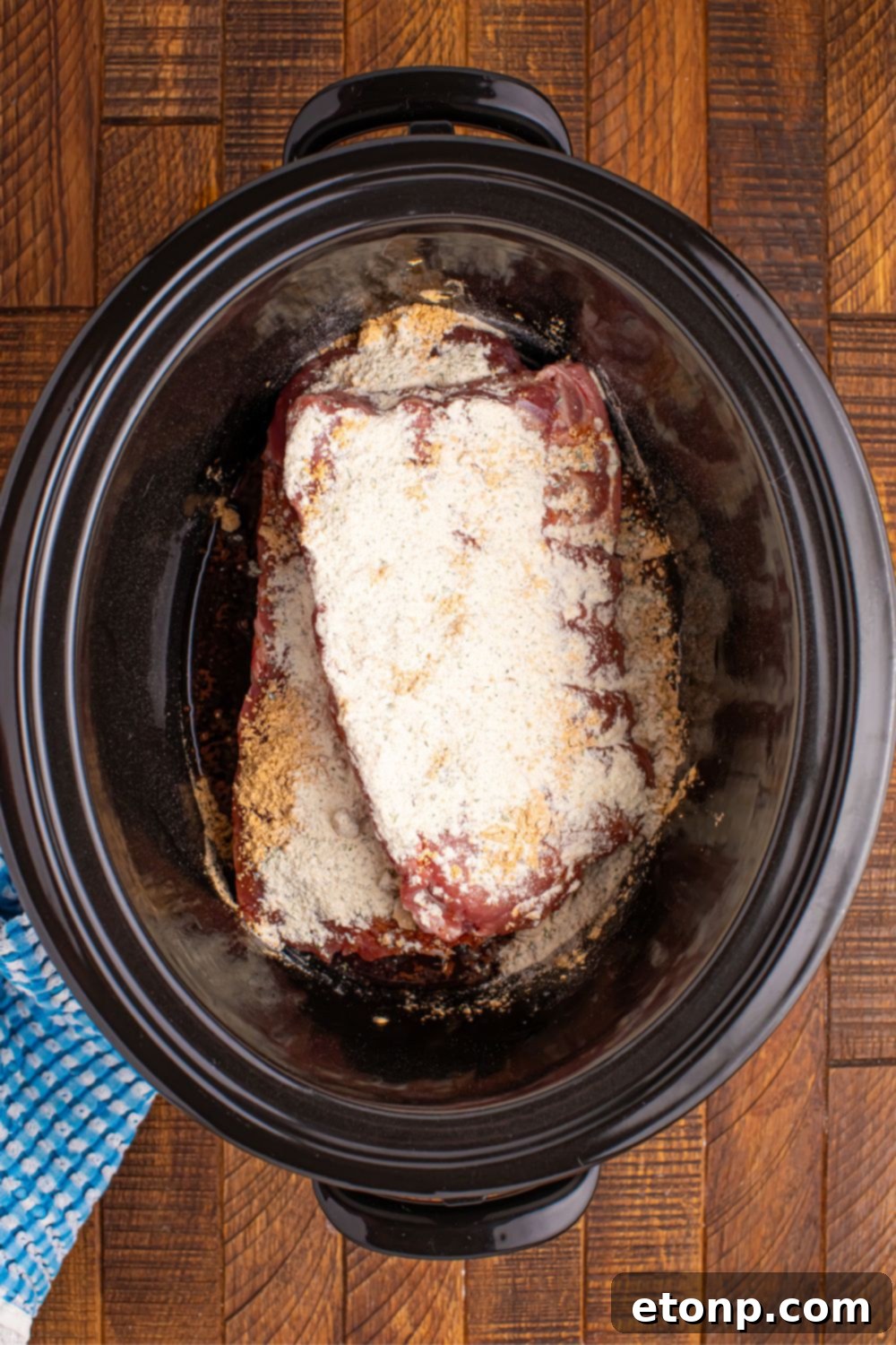 Overhead view of perfectly cooked Slow Cooker Mississippi Ribs in the slow cooker, glistening with sauce and surrounded by tender peppers.