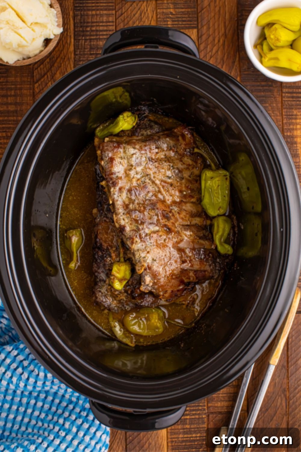 A close-up, overhead view of succulent cooked Slow Cooker Mississippi Ribs, ready to be served, showcasing their tender texture and rich sauce.