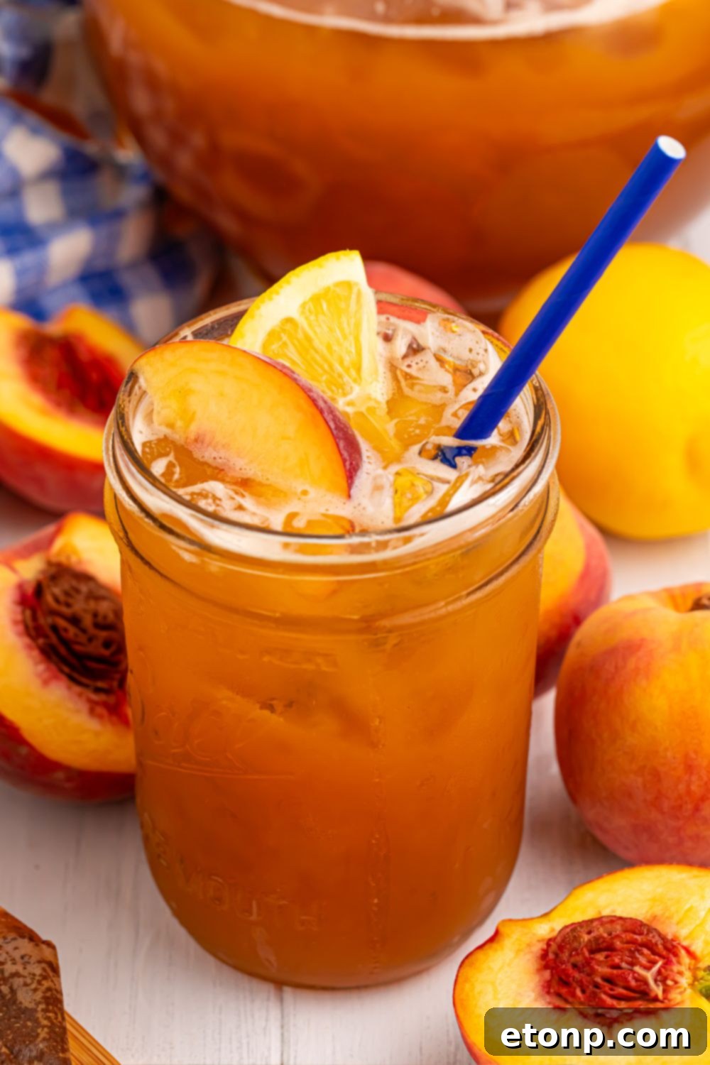 Southern Peach Infusion 2 glass of sweet peach tea and sliced peaches all around it on table