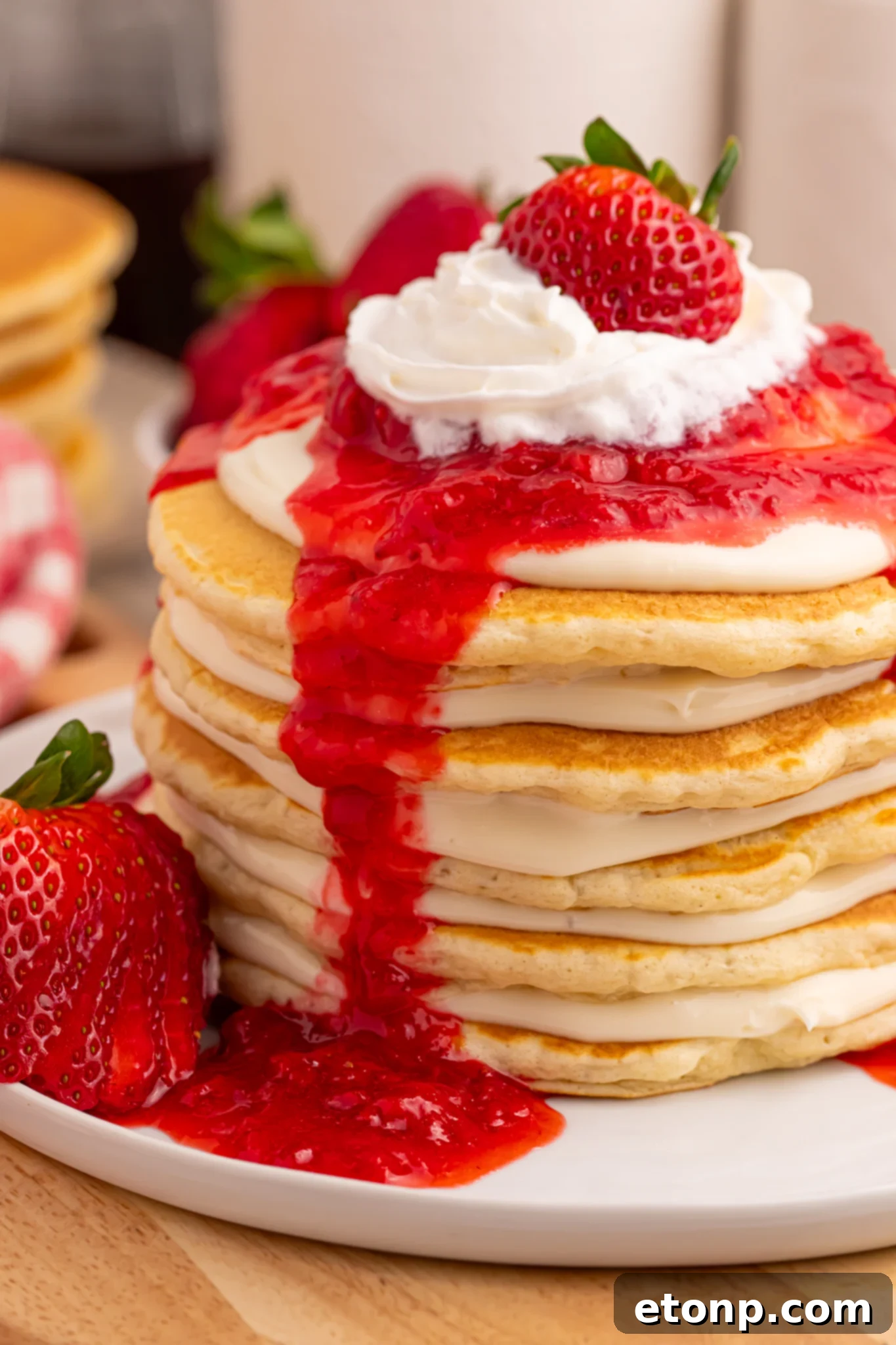 Artistic shot of Strawberry Cheesecake Pancakes with ingredients and a fork in the foreground