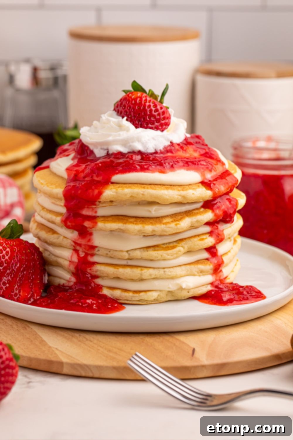 Strawberry Cheesecake Pancakes on a table with kitchen background elements