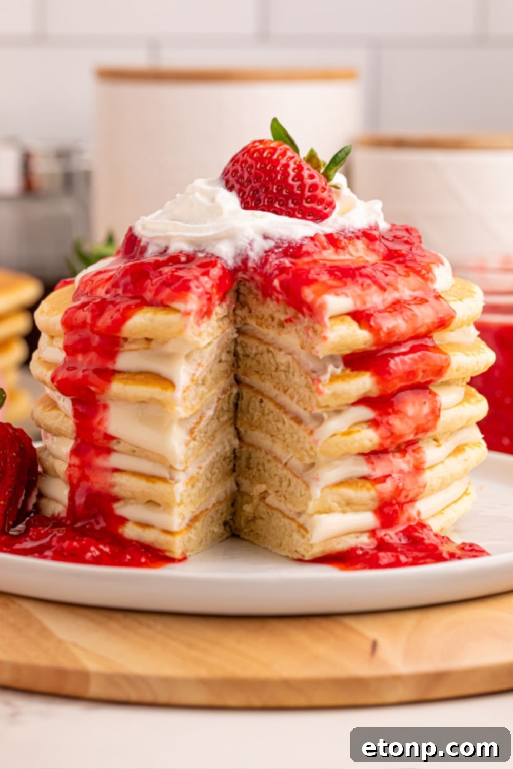Strawberry Cheesecake Pancakes stacked with a cross-section showing distinct cheesecake layers