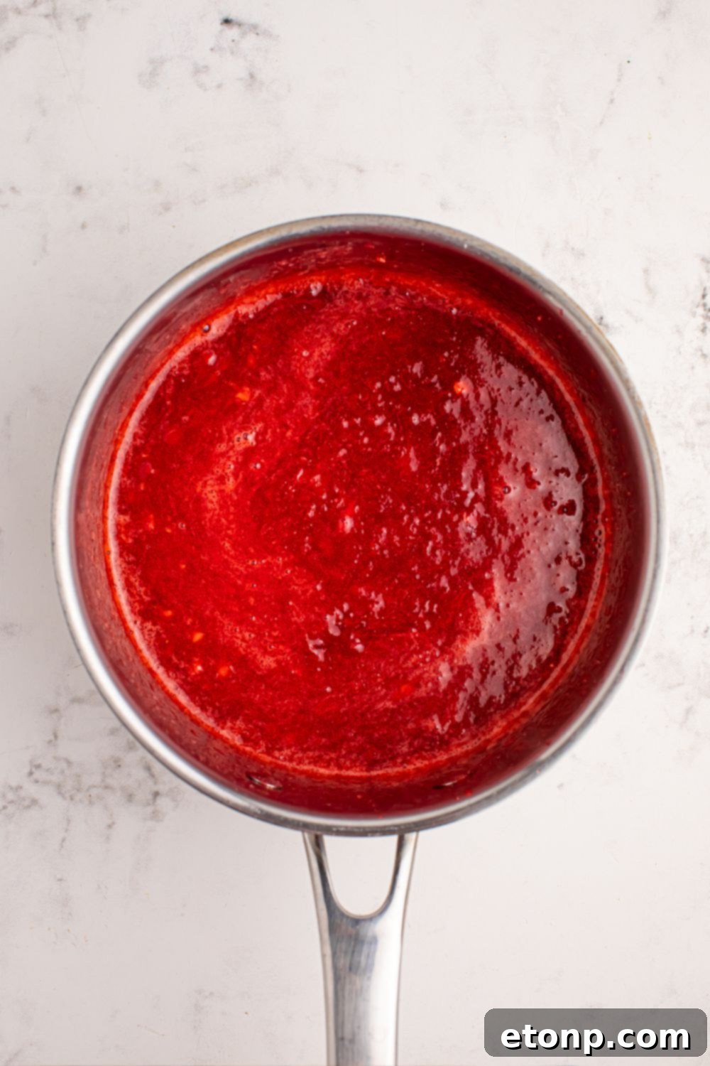 Strawberry sauce simmering in a saucepan