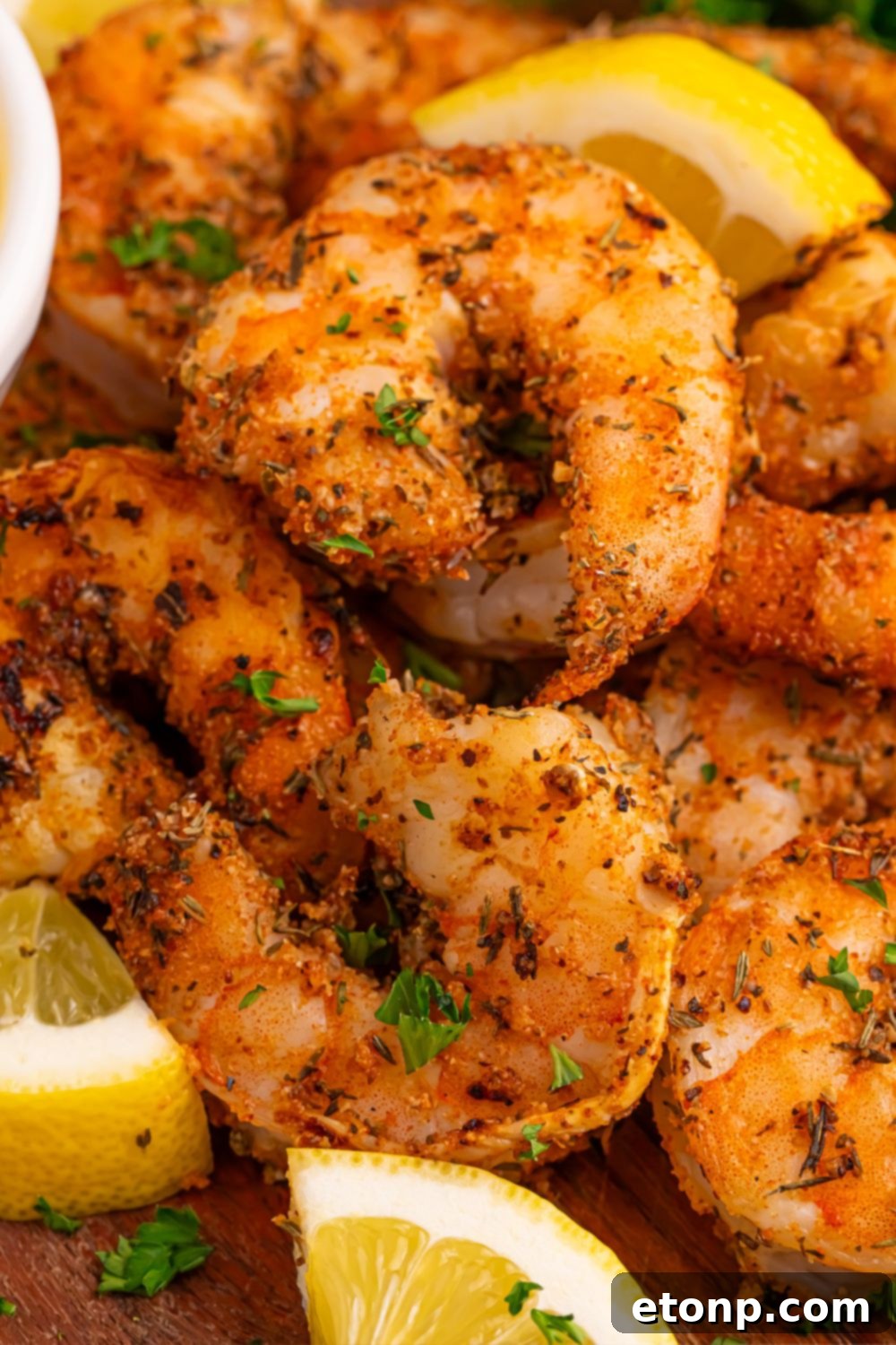 Perfectly grilled Cajun shrimp, beautifully cooked and arranged on a plate with fresh lemon wedges, ready to be served.