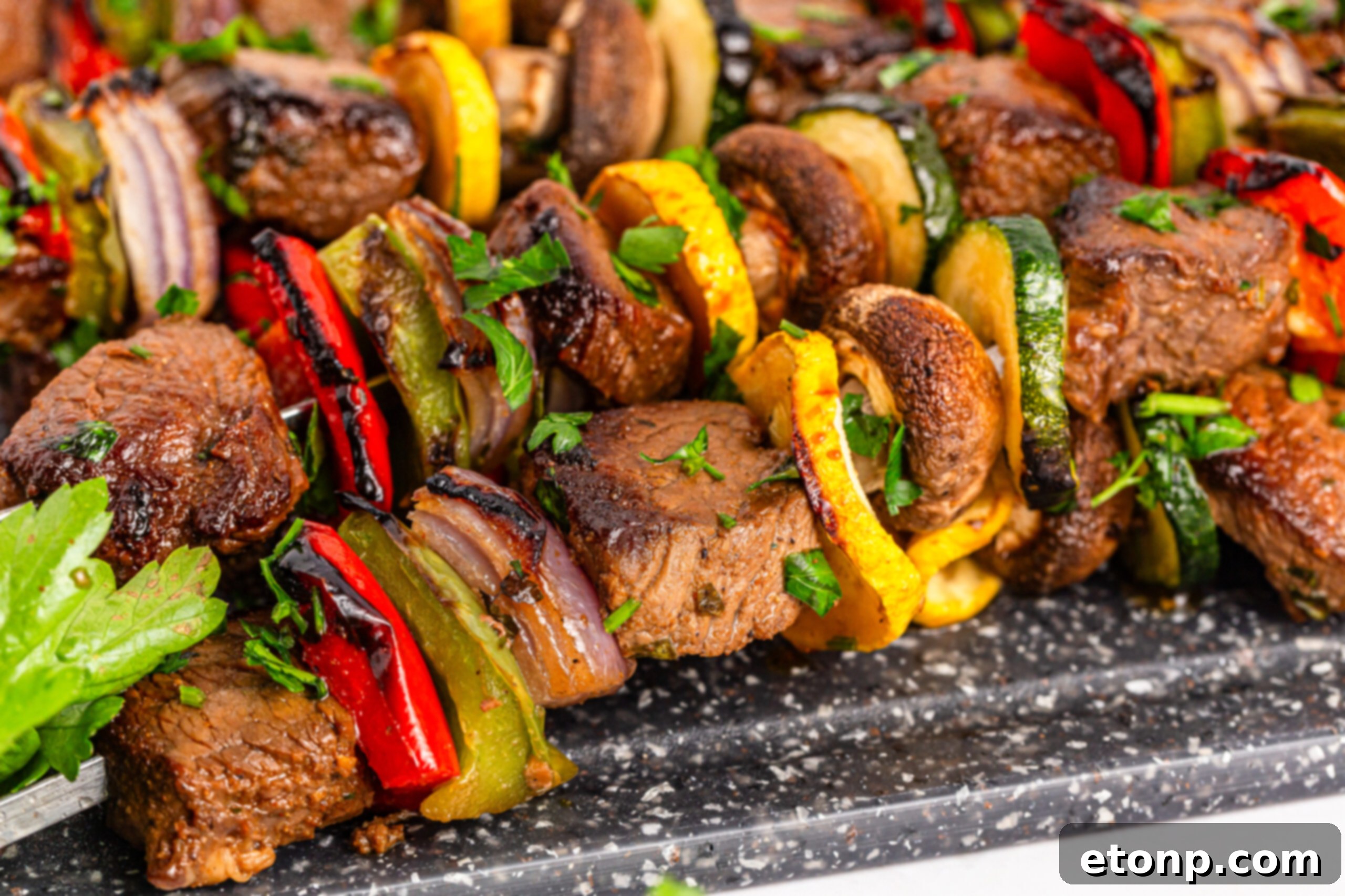up close shot of my Marinated Beef Kabobs stacked on top of each other on a tray 
