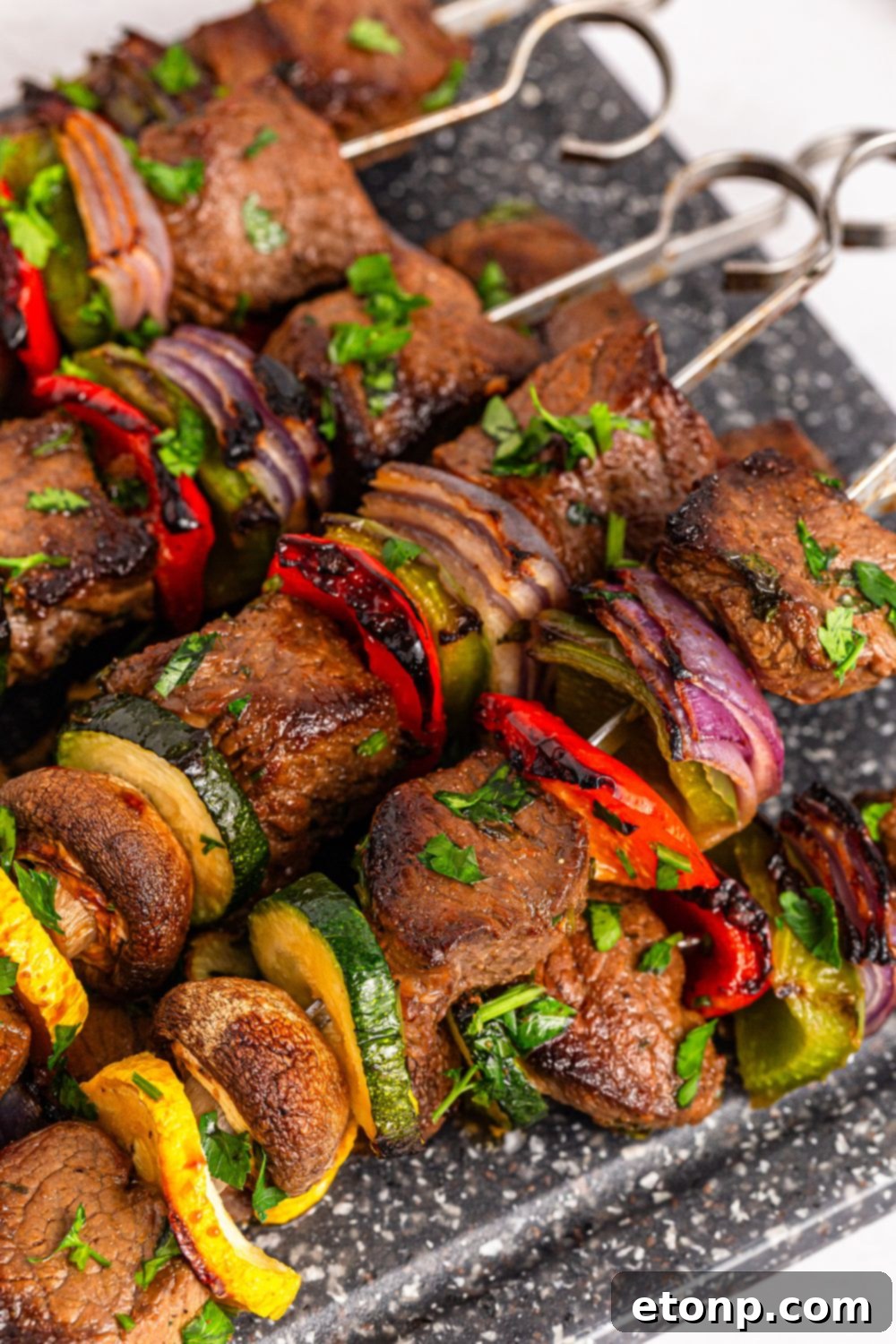 Marinated Beef Kabobs on a metal tray sitting on a table 