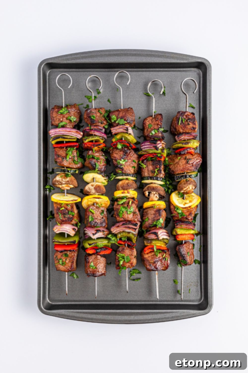 cooked Marinated Beef Kabobs on a baking sheet on table 