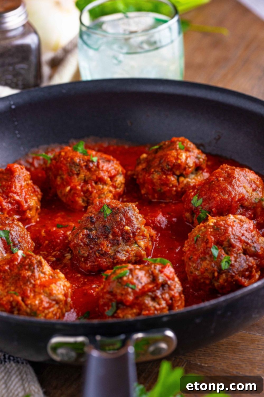 black skillet with meatballs and sauce on a table 