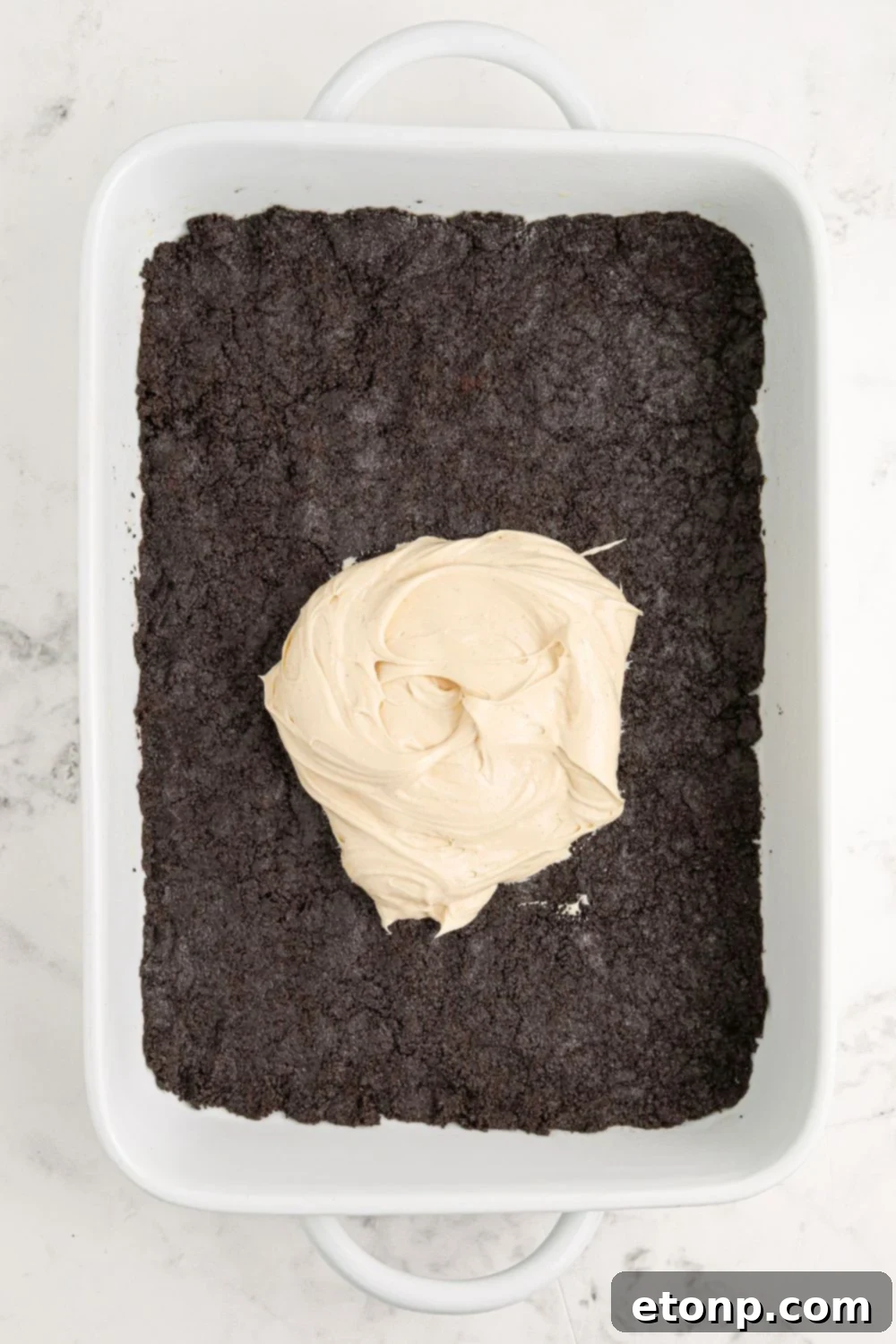 Reese's Peanut Butter Bliss Stack 9 The assembly of Reese's Lasagna begins with an Oreo crust evenly pressed into a pan, and a dollop of creamy peanut butter mixture in the center.
