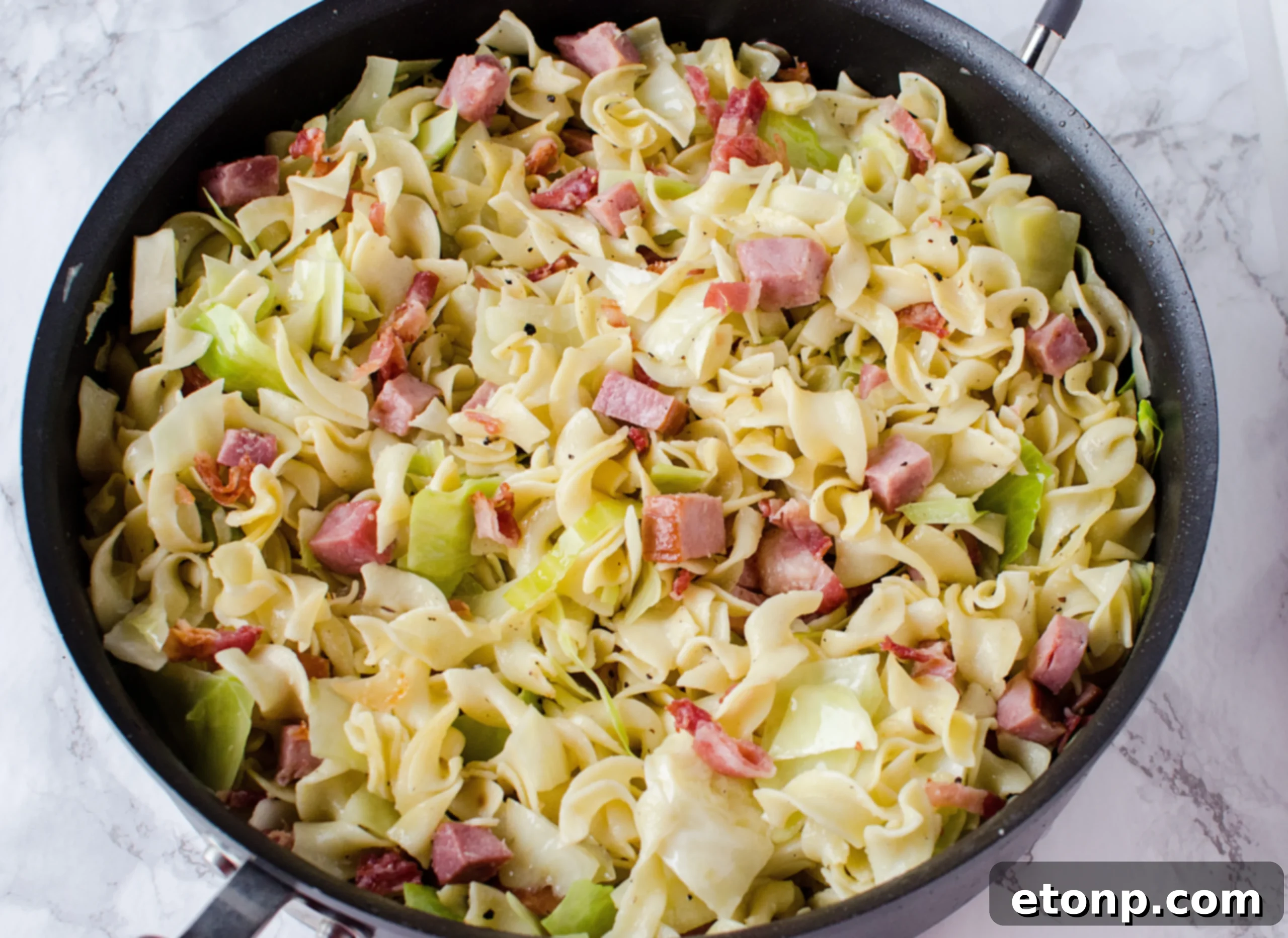 A close-up of the fully assembled Fried Cabbage, Ham & Noodles, showcasing the buttery sauce.