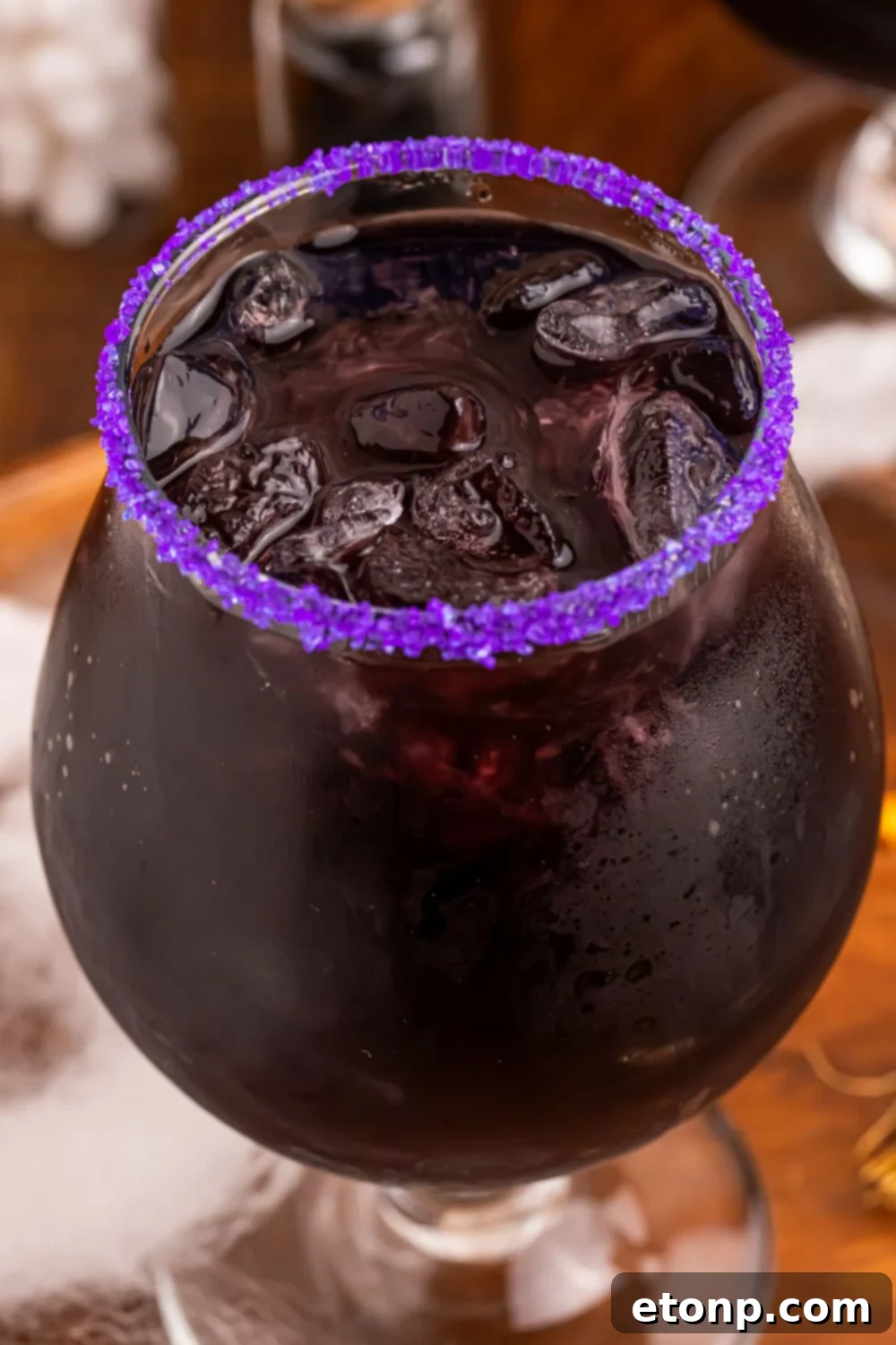 close up of Witches Brew Cocktail in a glass with a purple sugar rim