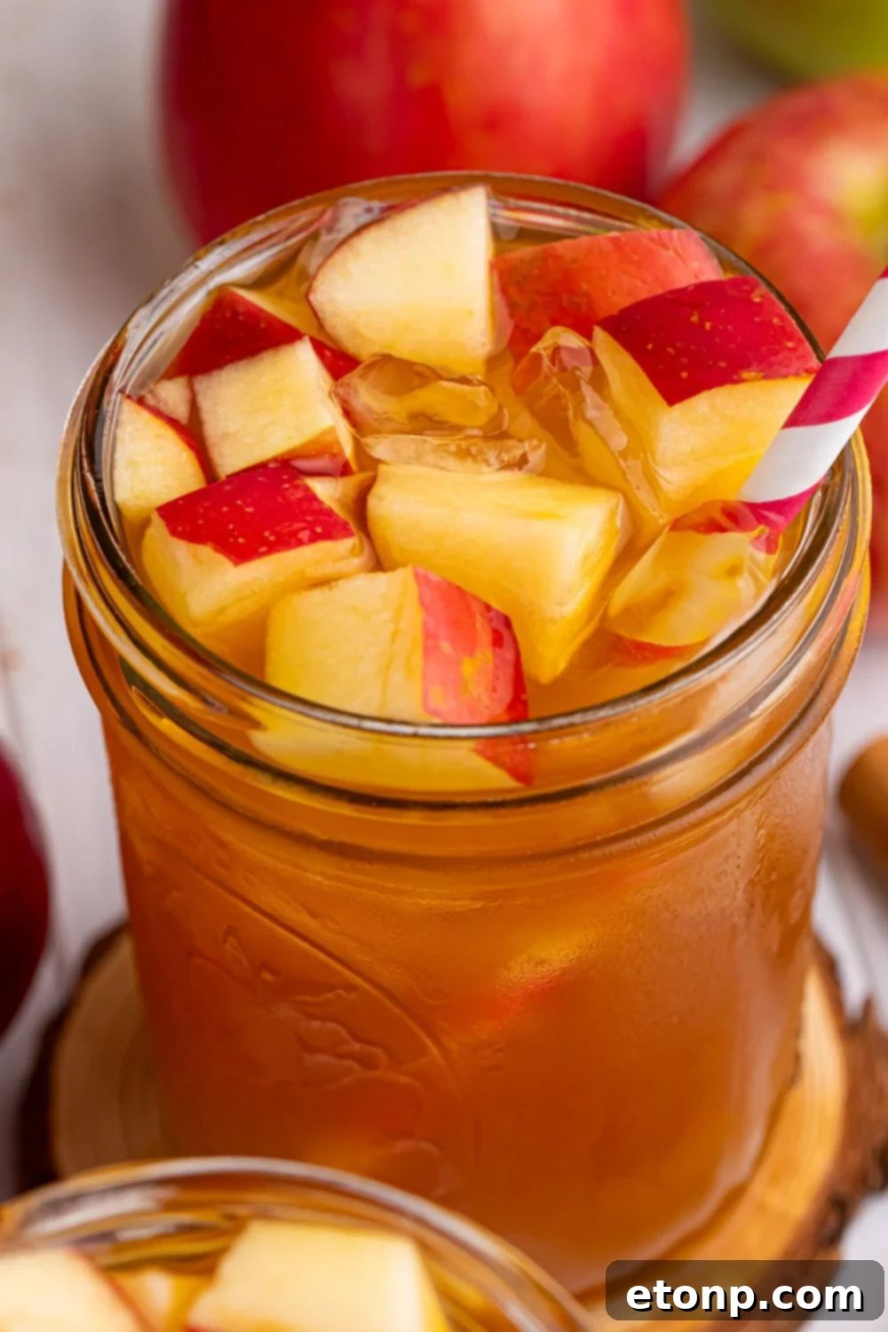 Orchard Apple Iced Tea 16 tea cider in a glass with diced apples and ice in the glass